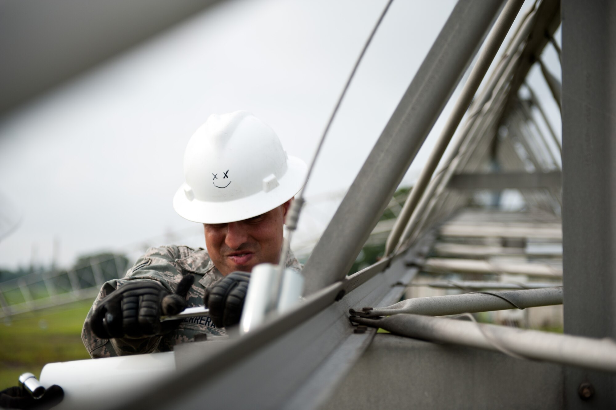 Airman 1st Class David Herrera, 374th Communications Squadron cable and antenna maintenance technician, tightens a bolt between a crystalline plastic support and piece of metal on a rotatable log periodic antenna July 26, 2013, at the Tokorozawa Communication Site, Japan. The plastic was replaced due to scheduled maintenance and will provide needed flexibility and support between antenna segments for 10 years before having to be replaced again. (U.S. Air Force photo by Senior Airman Cody H. Ramirez)