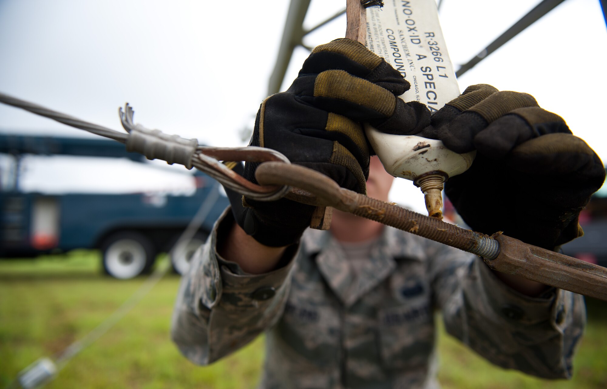 Airman 1st Class Mike Turland, 374th Communications Squadron cable and antenna maintenance technician, applies an anti-corrosive substance to threads of a rotatable log periodic antenna July 26, 2013, at the Tokorozawa Communication Site, Japan. Turland and his team lowered the RLP antenna to replace crystalline plastic used as support bridges between antenna segments. The replaced plastic had a 5-year life and was replaced by stronger pieces that only have to be replaced every 10 years. (U.S. Air Force photo by Senior Airman Cody H. Ramirez)