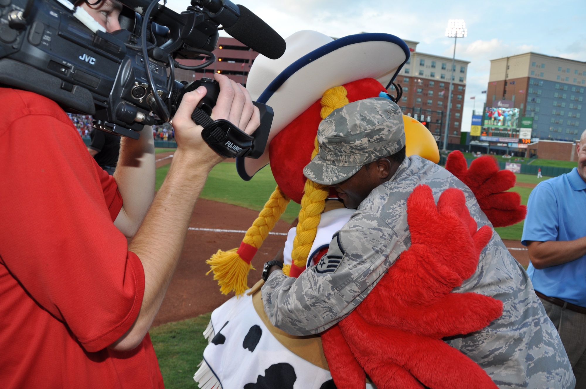 Master Sgt. Adrian Mack, 507th Maintenance Squadron gives Cooper the Oklahoma City RedHawks mascot a big hug after being recognized by the crowd at the military appreciation game July 27.  (U.S. Air Force Photo/Maj. Jon Quinlan)  