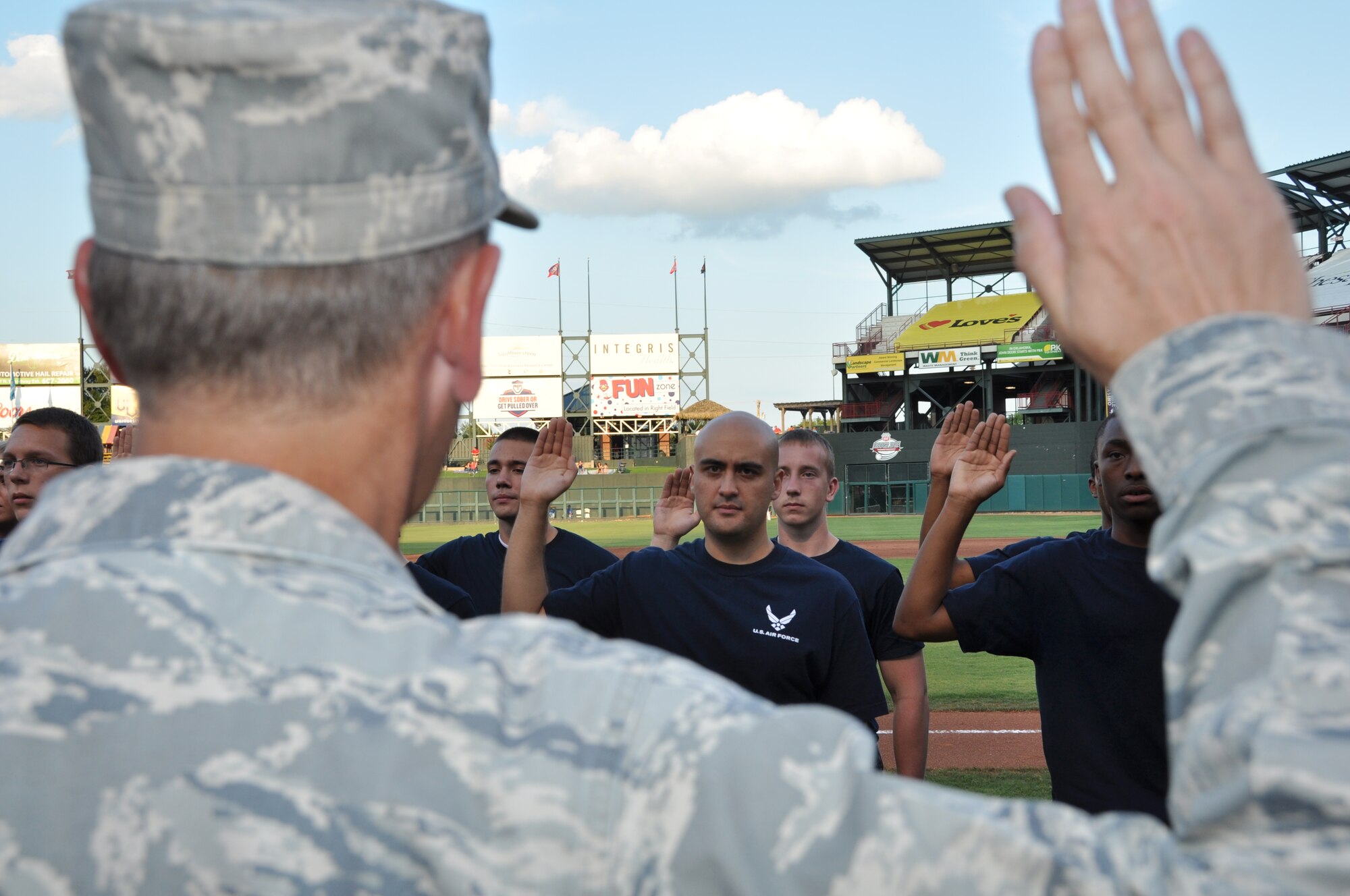 Stormy Archer of Oklahoma City takes the Air Force Oath of Enlistment at the Oklahoma City RedHawks game on July 27. Colonel Russell Muncy, 507th Air Refueling Wing commander administered the oath to 26 new recruits before the start of the 2nd inning.  Archer wanted to join the Air Force to follow the footsteps of his father.  He heads to basic military training in November and will be serving in the public affairs career field after BMT graduation. (U.S. Air Force Photo/Maj. Jon Quinlan) 