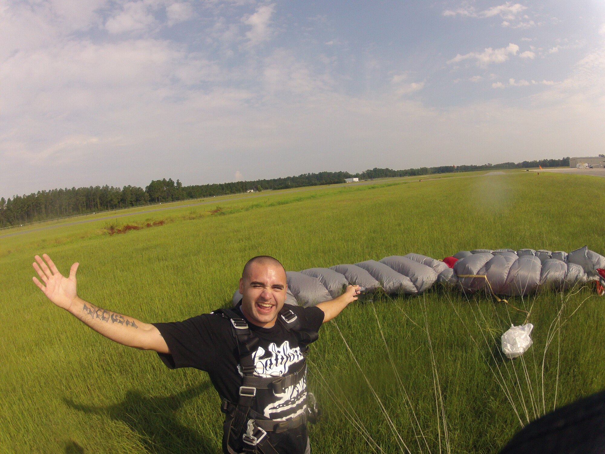 Senior Airman Kevin Crocchi, a munitions inspector with 1st Special Operations Equipment Maintenance Squadron, stands next to his parachute after skydiving 10,000 feet while at Skydive Panama City during a trip to their station at Altha, Florida, July 27, 2013.  Crocchi and fellow junior enlisted Airmen participated in the trip as part of the base's Single Airman Initiative Program. (Courtesy photo)
