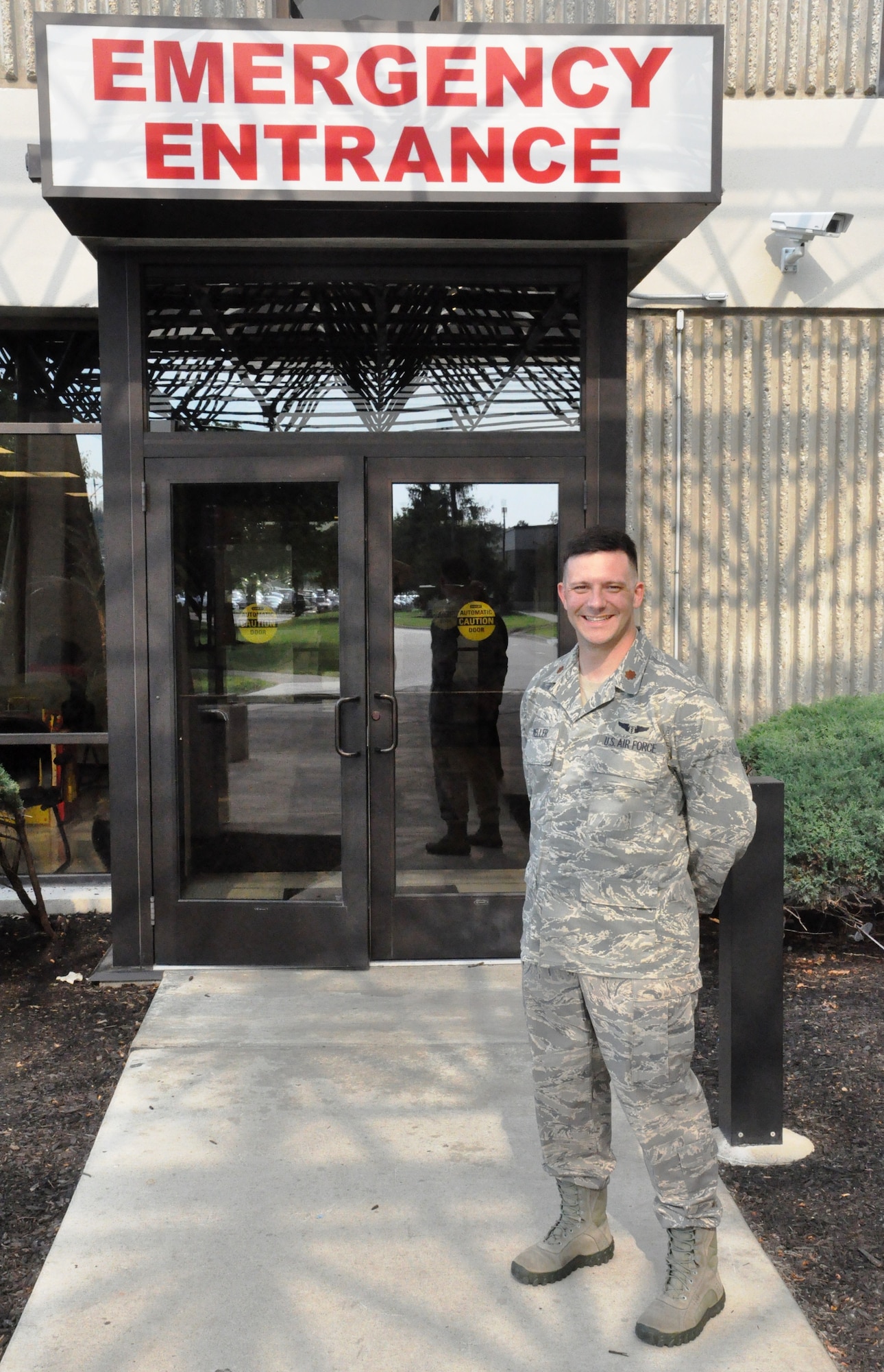 Major (Dr.) Alex Keller stands in front of Wright-Patterson Medical Center emergency room entrance.  The major helps local fire department on emergency runs. (U.S. Air Force photo by Ted Theopolos)