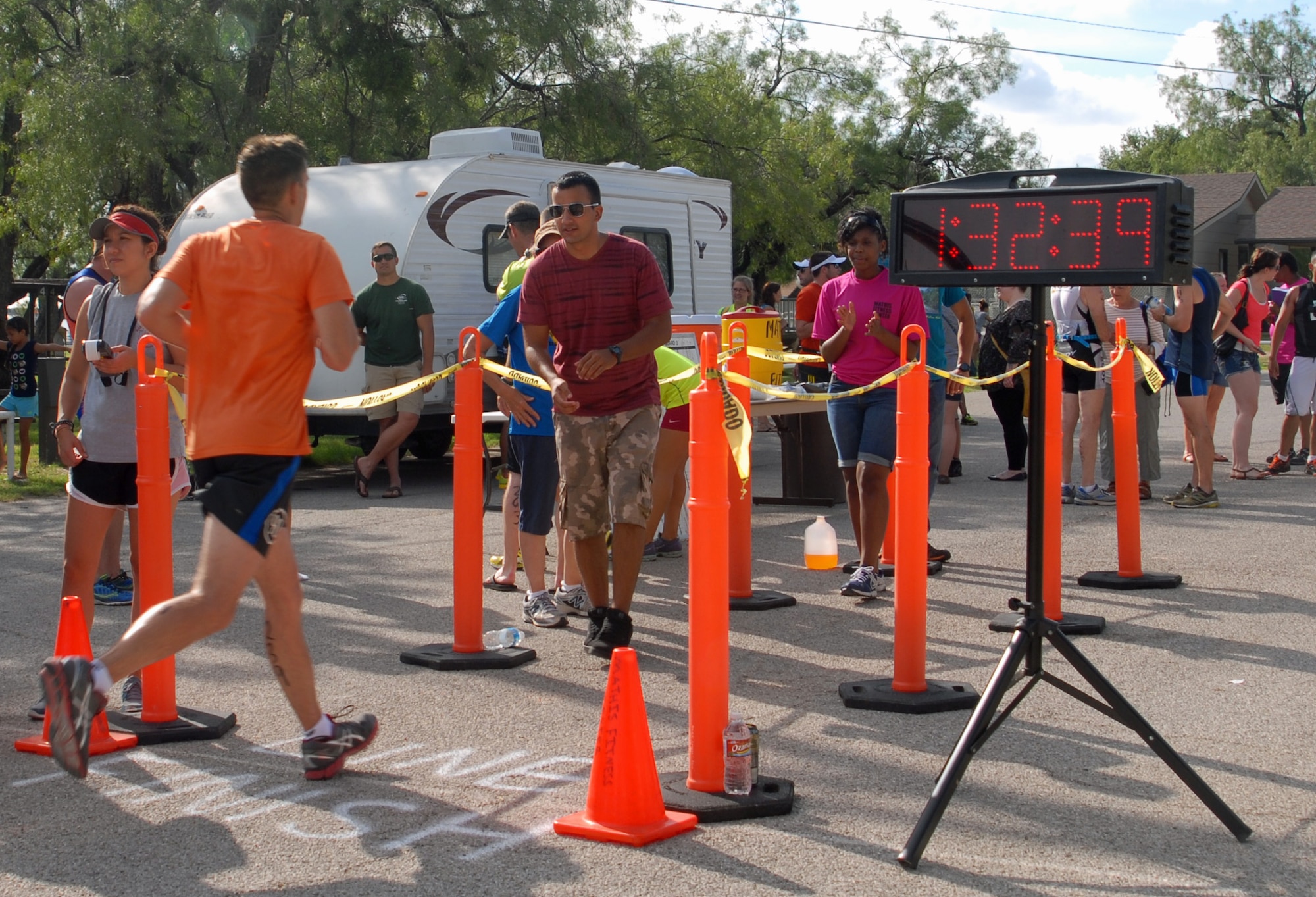 Volunteers cheer on a 2013 Annual Triathlon competitor at Goodfellow Recreation Camp July 27. After the triathlon, food and refreshments were provided for participants, volunteers and spectators. (U.S. Air Force photo/ Airman 1st Class Breonna Veal)