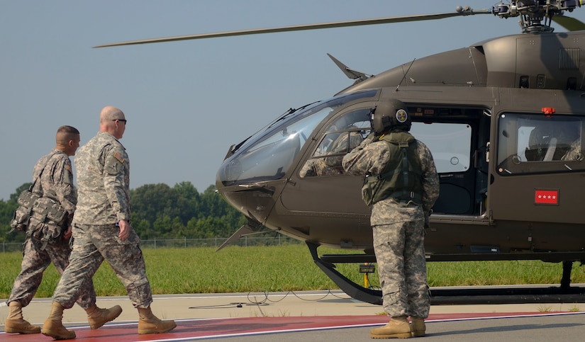 U.S. Army General Robert Cone (Center), Training and Doctrine Command commander, boards a TRADOC flight detachment UH-72A light utility helicopter at Fort Eustis, Va., July 19, 2013. The detachment helicopters shuttle the commander and other dignitaries to different locations across the nation. (U.S. Air Force photo by Airman 1st Class Austin Harvill/Released)