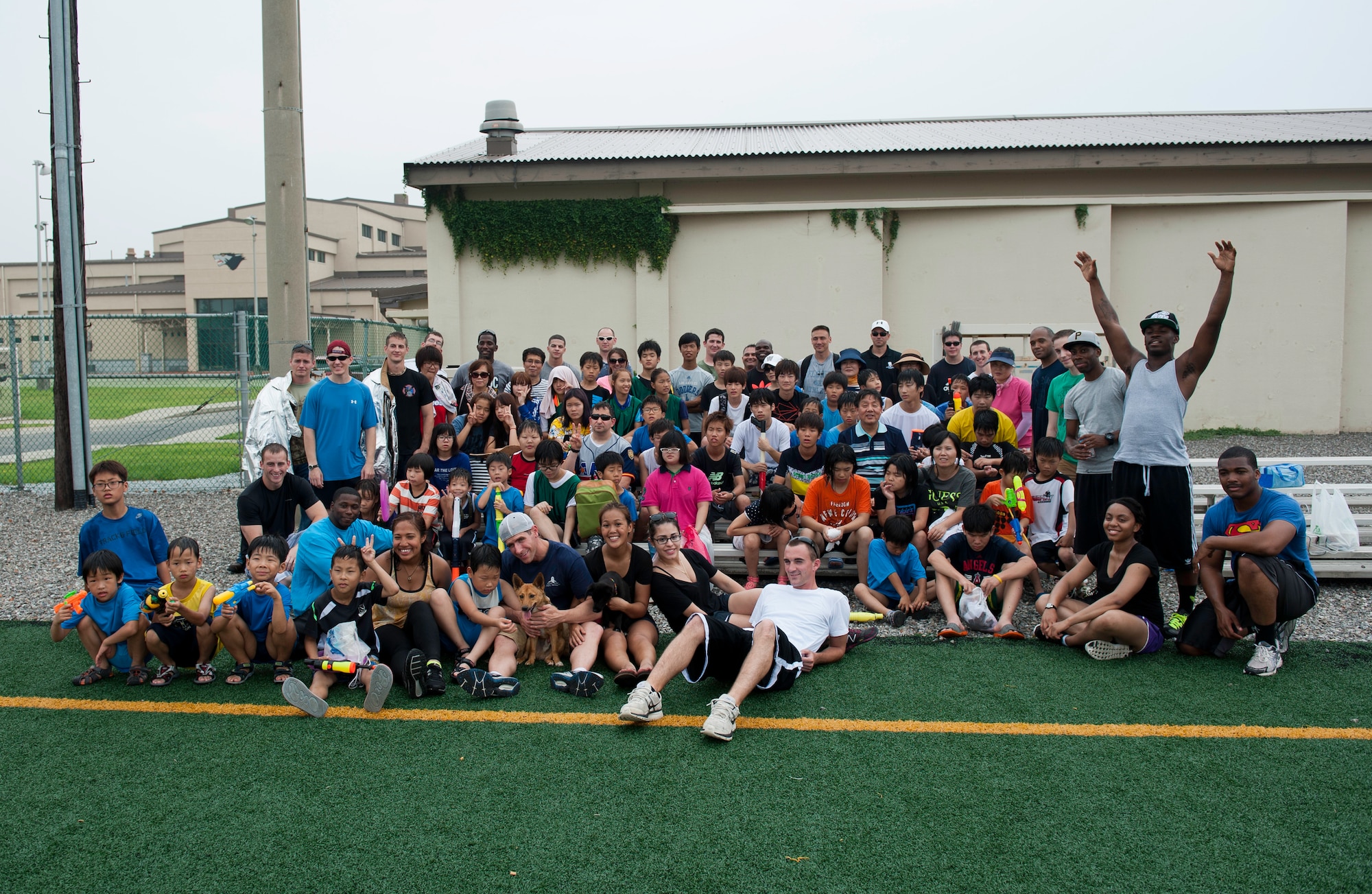 Wolf Pack Airmen and children from the Ilmagwon Orphanage end Summer Fun Day with a group photo, at Kunsan Air Base, Republic of Korea, July 27, 2013. The fun day was organized by the Airmen Committed to Excellence Council and gave the orphanage an opportunity to interact with members of the Wolf Pack in a variety of fun activities. (U.S. Air Force photo by Senior Airman Clayton Lenhardt/Released)