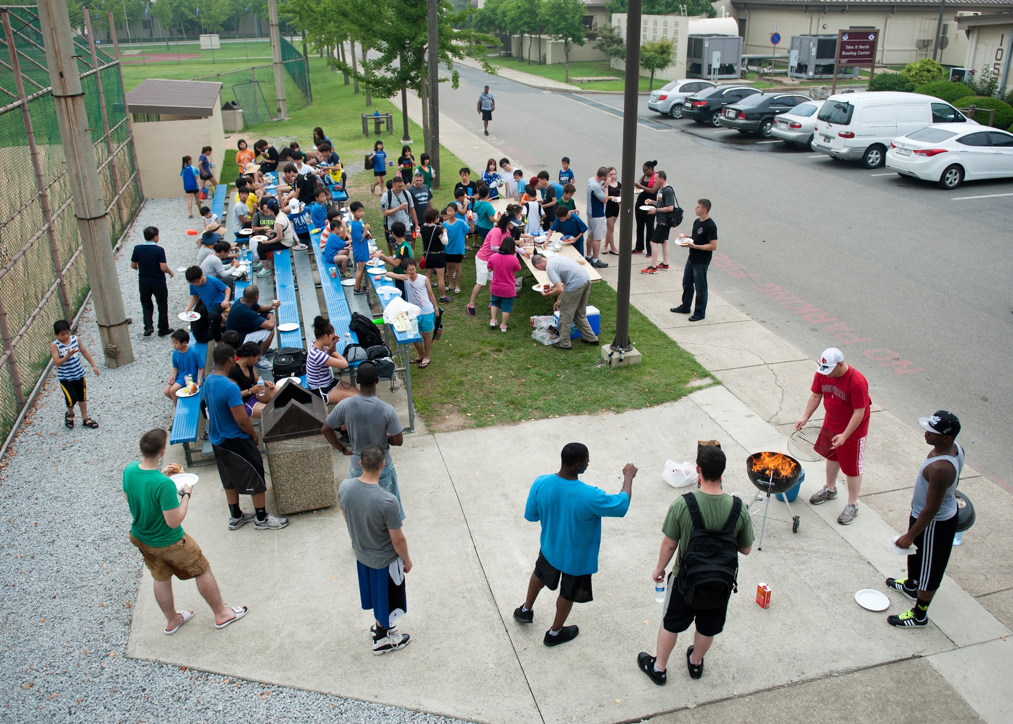 Wolf Pack Airmen and children from the Ilmagwon Orphanage take a break for hotdogs and chips during Summer Fun Day, at Kunsan Air Base, Republic of Korea, July 27, 2013. More than 60 children were invited to the base by the Airmen Committed to Excellence Council for a chance to have fun with members of the Wolf Pack. (U.S. Air Force photo by Senior Airman Clayton Lenhardt/Released)