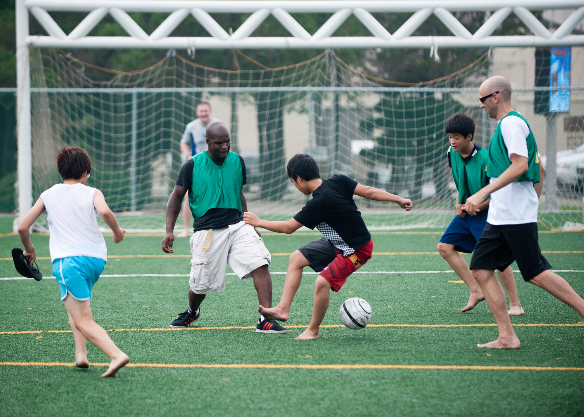 Wolf Pack Airmen and children from the Ilmagwon Orphanage play soccer during Summer Fun Day, at Kunsan Air Base, Republic of Korea, July 27, 2013. More than 60 children from the orphanage visited the base for the activity day hosted by the Airmen Committed to Excellence Council. (U.S. Air Force photo by Senior Airman Clayton Lenhardt/Released)