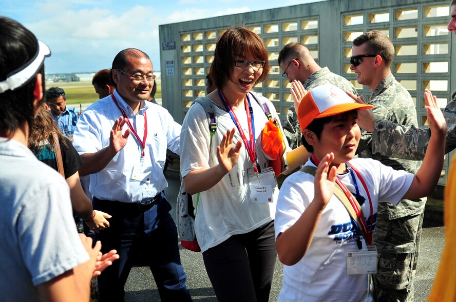 U.S. Air Force Airmen and American military children welcome Japanese sixth-graders and escorts from Iitate Village to Kadena Air Base, Japan, July 24, 2013. The students had the opportunity to watch several rescue demonstrations in order to learn more about the peaceful operations the U.S. military performs. (U.S. Air Force photo by Senior Airman E. N. Jacobs/Released)