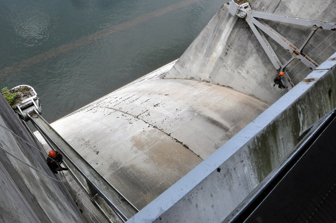 Suspended by rappelling cables and ropes 200 feet in the air along side Wolf Creek Dam in Jamestown, Ky., Chad Dahl (Left) and Eddie Page, (right)  two civil engineer contractors from the U.S. Army Corps of Engineers Philadelphia District inspect 10 tainter gates for signs of corrosion or structural damage on July 24, 2013.  