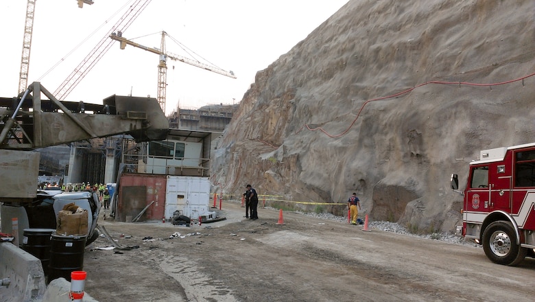 Emergency personnel respond to the scene after a vehicle, shown at left, plunged more than 100 feet into the Folsom Dam auxiliary spillway project construction site in Folsom, Calif., July 30, 2013. Employees of the project contractor, Granite Construction Inc., were the first to respond to the incident and safely extracted the driver from the vehicle. An electrical cable supplying power to the project was the only damage to the construction site. Work is expected to resume during the evening of July 30. 