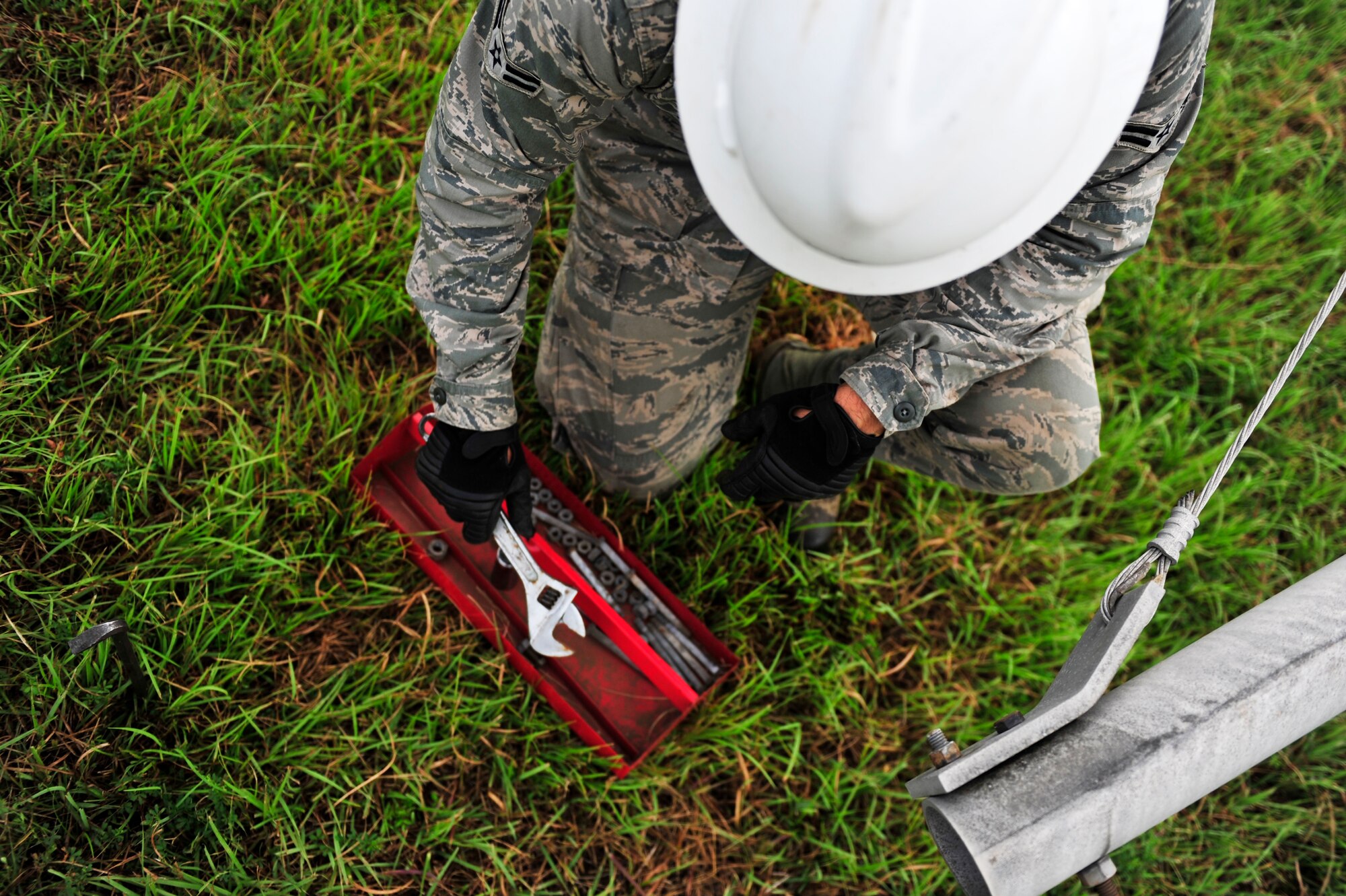 An airman 1st class assigned to the 374th Communications Squadron cable and antenna maintenance shop removes a wrench from his tool box July 26, 2013, during scheduled maintenance at the Tokorozawa Communication Site, Japan. The maintenance consisted of replacing crystalline plastic used as support bridges between antenna segments. Each plastic piece had a life cycle of 5 years, but was replaced by newer, stronger plastic which will last 10 years before needing to be replaced. (U.S. Air Force photo by Senior Airman Cody H. Ramirez)