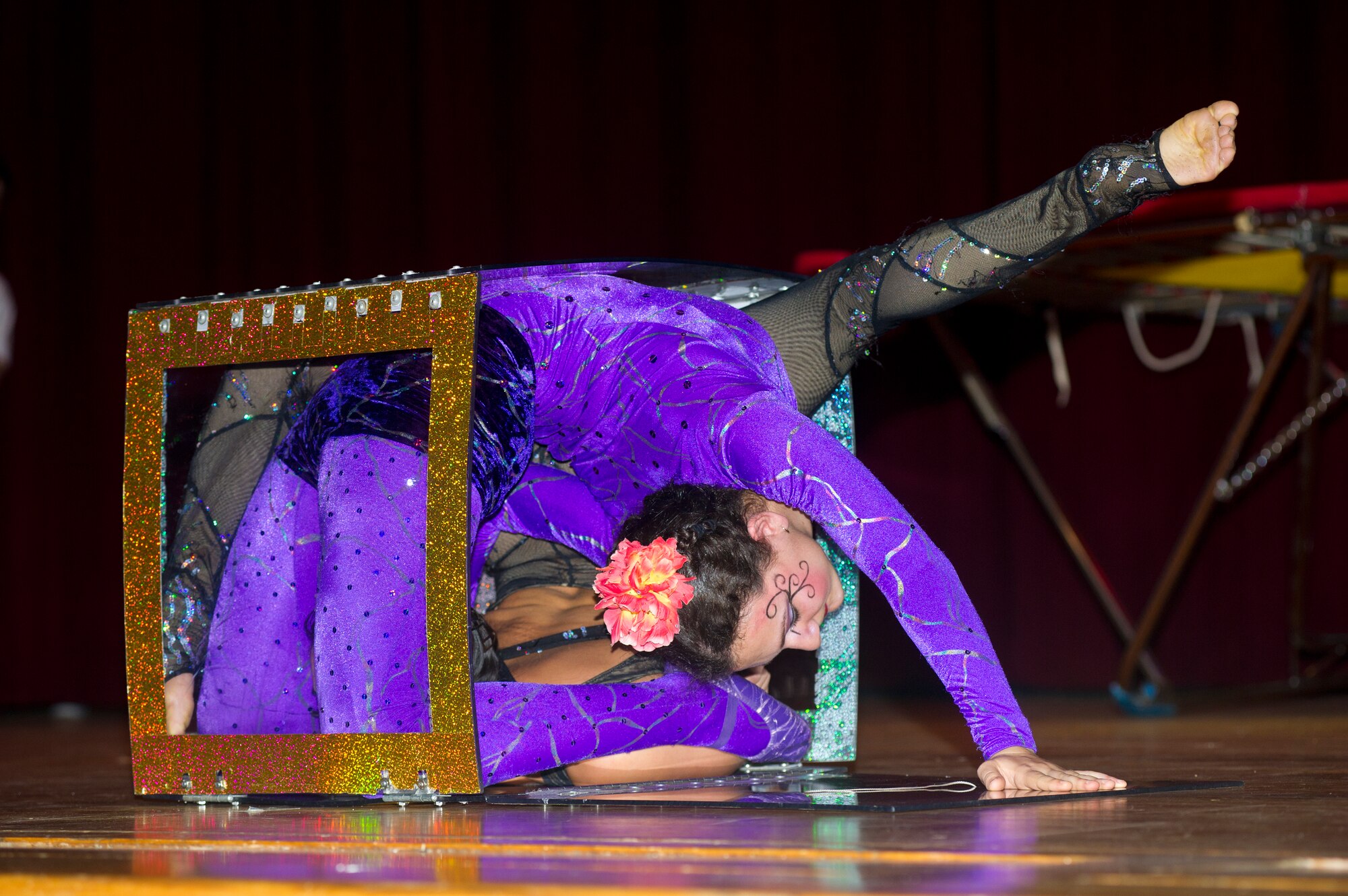 Two Funambula performers contort to fit inside a box during a military appreciation show, July 27, 2013, at Welch Theater, Keesler Air Force Base, Miss. Funambula is a theatrical circus act including many acrobatic acts as well as contortionists. (U.S. Air Force photo by Adam Bond)