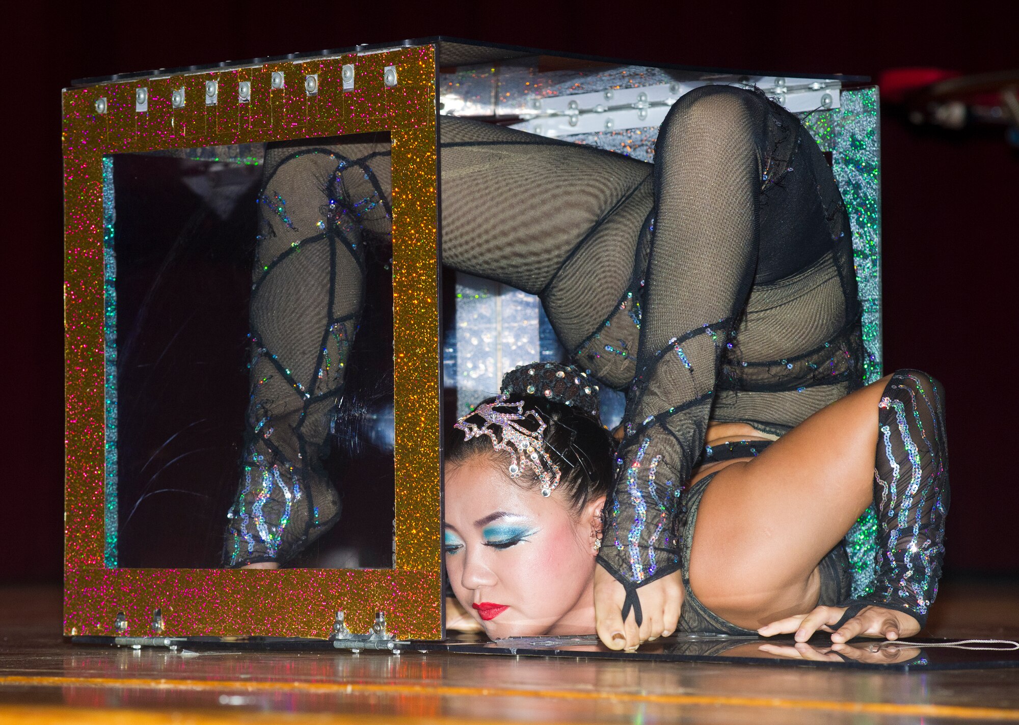 A Funambula performer contorts herself backward and inches into a box during a military appreciation show, July 27, 2013, at Welch Theater, Keesler Air Force Base, Miss. Funambula is a theatrical circus act including many acrobatic acts as well as contortionists. (U.S. Air Force photo by Adam Bond)