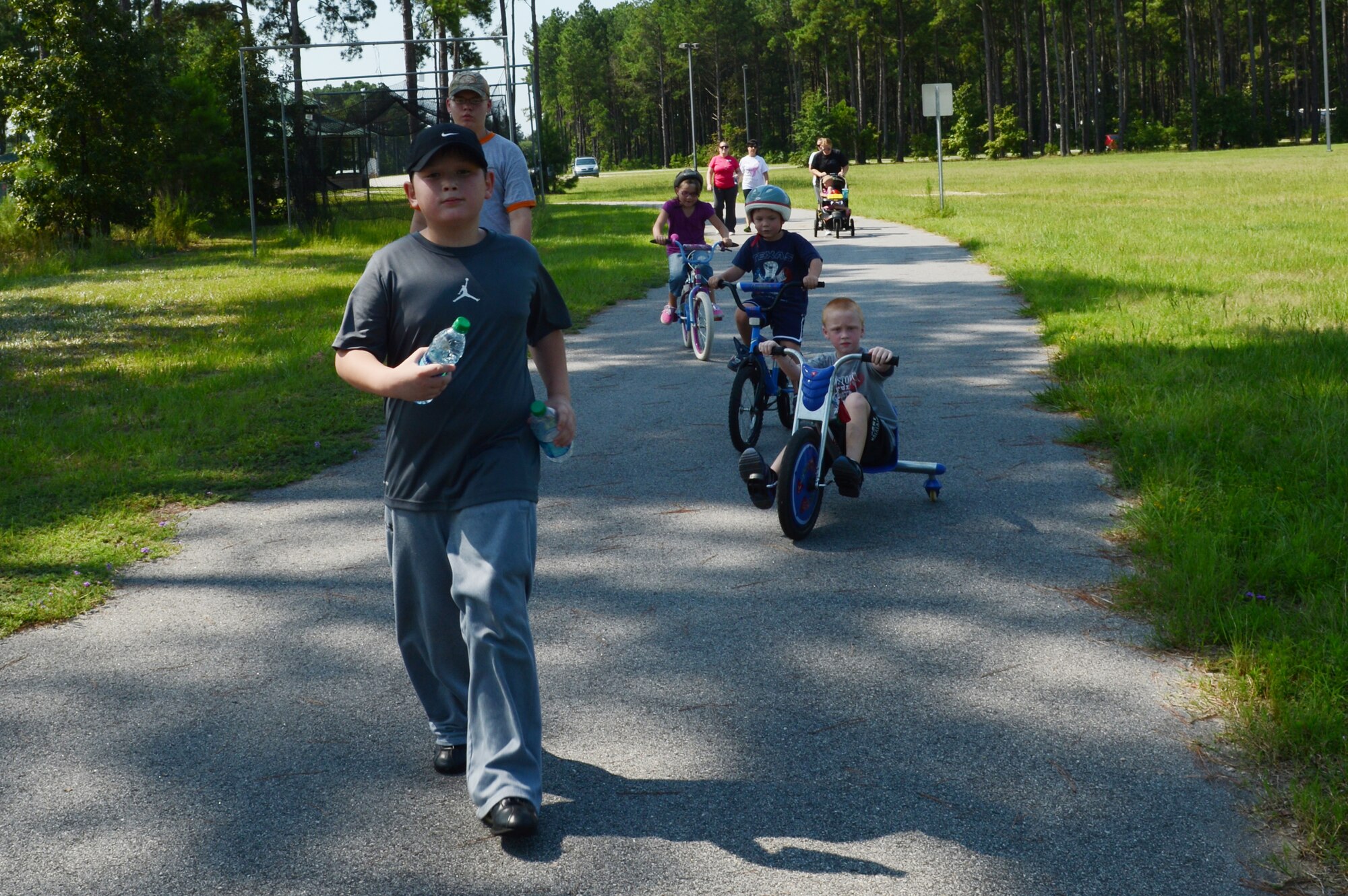 Team Shaw spouses and their children walk and ride bikes as part of the stroller club at the sports complex, Shaw Air Force Base, S.C., July 17, 2013. The stroller club, designed to help military spouses connect and relieve their stress through exercise, meets every Monday and Wednesday. (U.S. Air Force photo by Airman 1st Class Krystal M. Jeffers/Released)