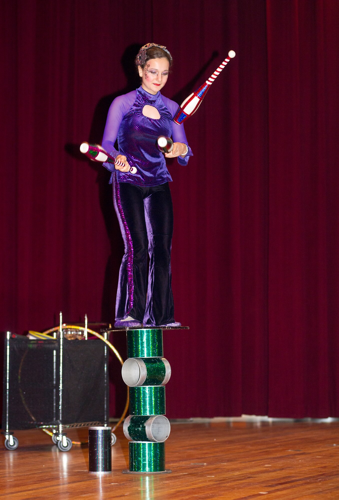 A Funambula performer juggles three clubs while rotating on a balanced stack of cylinders as part of a military appreciation performance, July 27, 2013, at Welch Theater, Keesler Air Force Base, Miss. Funambula is a theatrical circus act including many acrobatic acts as well as contortionists. (U.S. Air Force photo by Adam Bond)