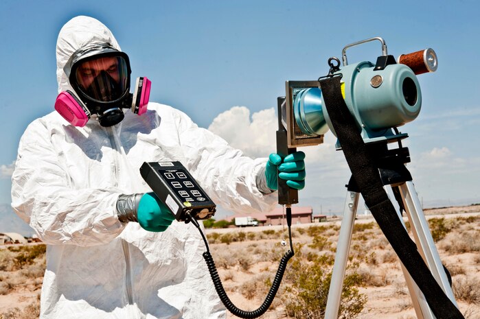 U.S. Air Force Senior Airman Nicholas Johnson, 99th Aerospace Medicine Squadron bioenvironmental engineer journeyman, simulates using an ADM 300, an instrument that measures radiation in the air during emergency responses July 25, 2013, at Nellis Air Force Base, Nev. When bioenvironmental engineering first responders use an ADM 300 and haven’t identified what they are sampling, they wear a Tybex suit which protects them from contamination. (U.S. Air Force photo by Senior Airman Daniel Hughes)