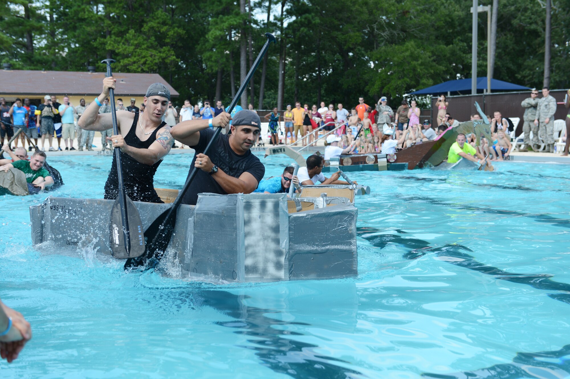 Team Shaw service members compete in a Cardboard Regatta boat race  during the Junior Enlisted Appreciation Day Celebration at Shaw Air Force Base, S.C., July 26, 2013. Team Shaw units built boats out of cardboard and duct Tape and raced from one end of the Woodland Pool here to the other and back. The winners of the competition were U.S. Air Force Senior Airmen Nicholas Evans and Alexander  Aldridge, 20th Logistic Readiness Squadron vehicle operators. . (U.S. Air Force photo by Airman 1st Class Krystal M. Jeffers/Released)