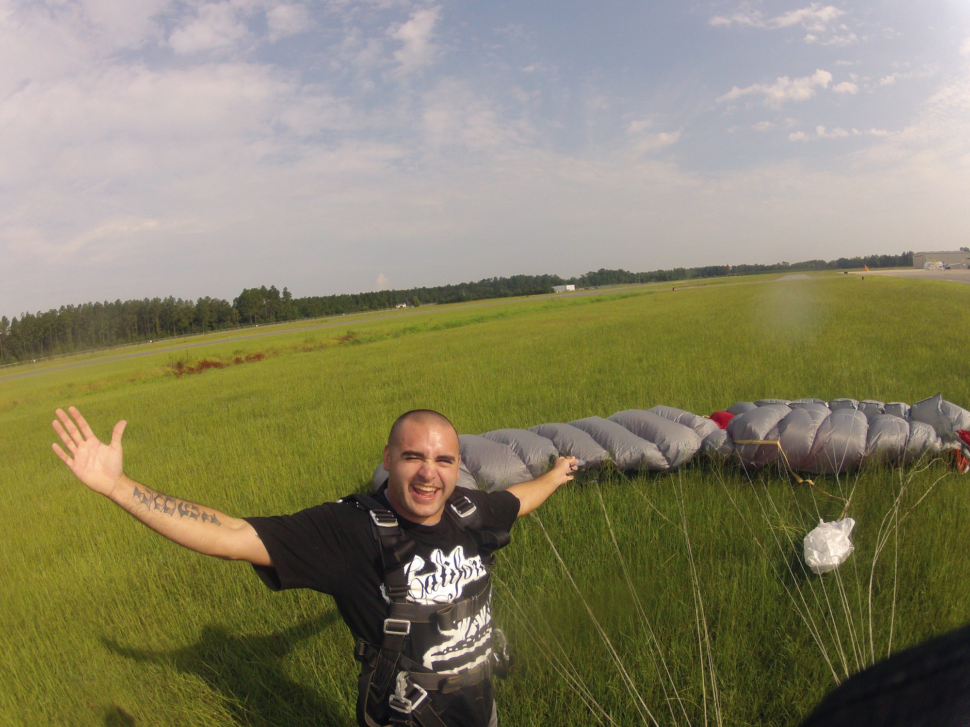 Senior Airman Kevin Crocchi, a munitions inspector with 1st Special Operations Equipment Maintenance Squadron, stands next to his parachute after skydiving 10,000 feet while at Skydive Panama City during a trip to their station at Altha, Florida, July 27, 2013.  Crocchi and fellow junior enlisted Airmen participated in the trip as part of the base's Single Airman Initiative Program. (Courtesy photo)