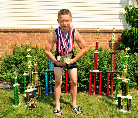 Francis Morrisey, son of Master Sgt. Francis Morrissey III, recently retired from the 436th Maintenance Squadron, poses with his wrestling trophies and medals July 19, 2013, at Dover Air Force Base, Del. Morrissey is an All-American wrestler after winning the Eastern Nationals Wrestling Championship in May. (U.S. Air Force photo/Tech. Sgt. Chuck Walker)