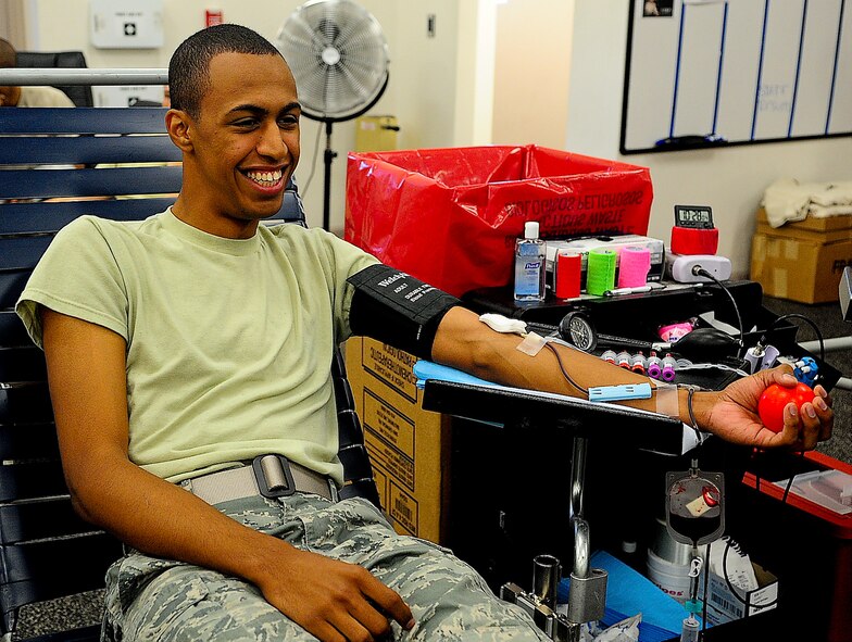 Airman 1st Class Joshua Hernandez, 436th Logistic Readiness Squadron individual protective equipment journeyman,  squeezes a stress ball as he donates blood July 29, 2013, at Dover Air Force Base, Del. One unit of blood has the potential to save three lives. (U.S. Air Force photo/Airman 1st Class Ashlin Federick)