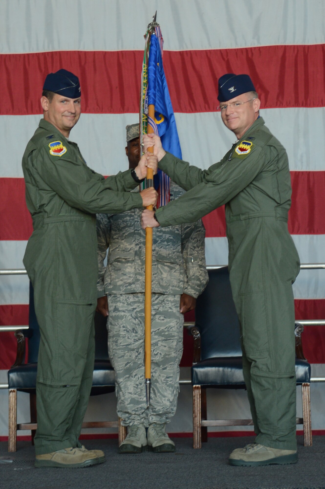 U.S. Air Force Col. Clay Hall, 20th Fighter Wing commander (left), passes the guide-on to the incoming  20th Operations Group Commander, U.S. Air Force Col. Paul Murray (right) during a change-of-command ceremony at Shaw Air Force Base, S.C. July 26, 2013. Hall presided over the ceremony where Murray took command of the 20th OG from U.S. Air Force Col. Shaun McGrath. (U.S. Air Force photo by Airman 1st Class Jonathan Bass/Released)