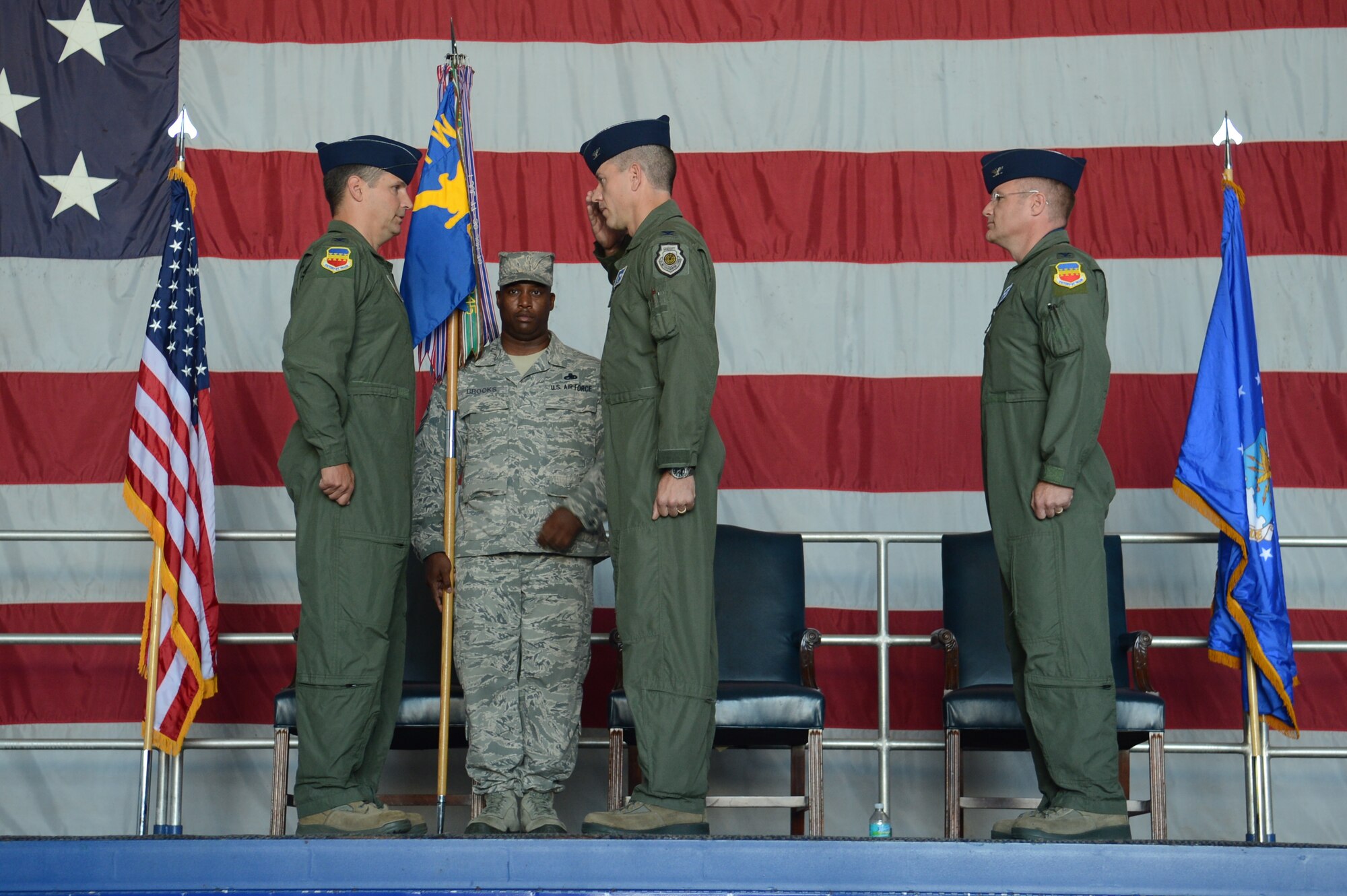 U.S. Air Force Col. Shaun McGrath, former 20th Operations Group commander, salutes Col. Clay Hall, 20th Fighter Wing commander, as Col. Paul Murray, new 20th OG commander, waits to receive command of the group; as Chief Master Sergeant Jerald Brooks , 20th OG superintendent holds the guide-on during a change-of-command ceremony, Shaw Air Force Base, S.C., July 26, 2013. McGrath relinquished command of the 20th Operations Group to Murray before departing to take command of an Expeditionary Operations Group at an undisclosed location. (U.S. Air Force photo by Airman 1st Class Jonathan Bass/Released)
