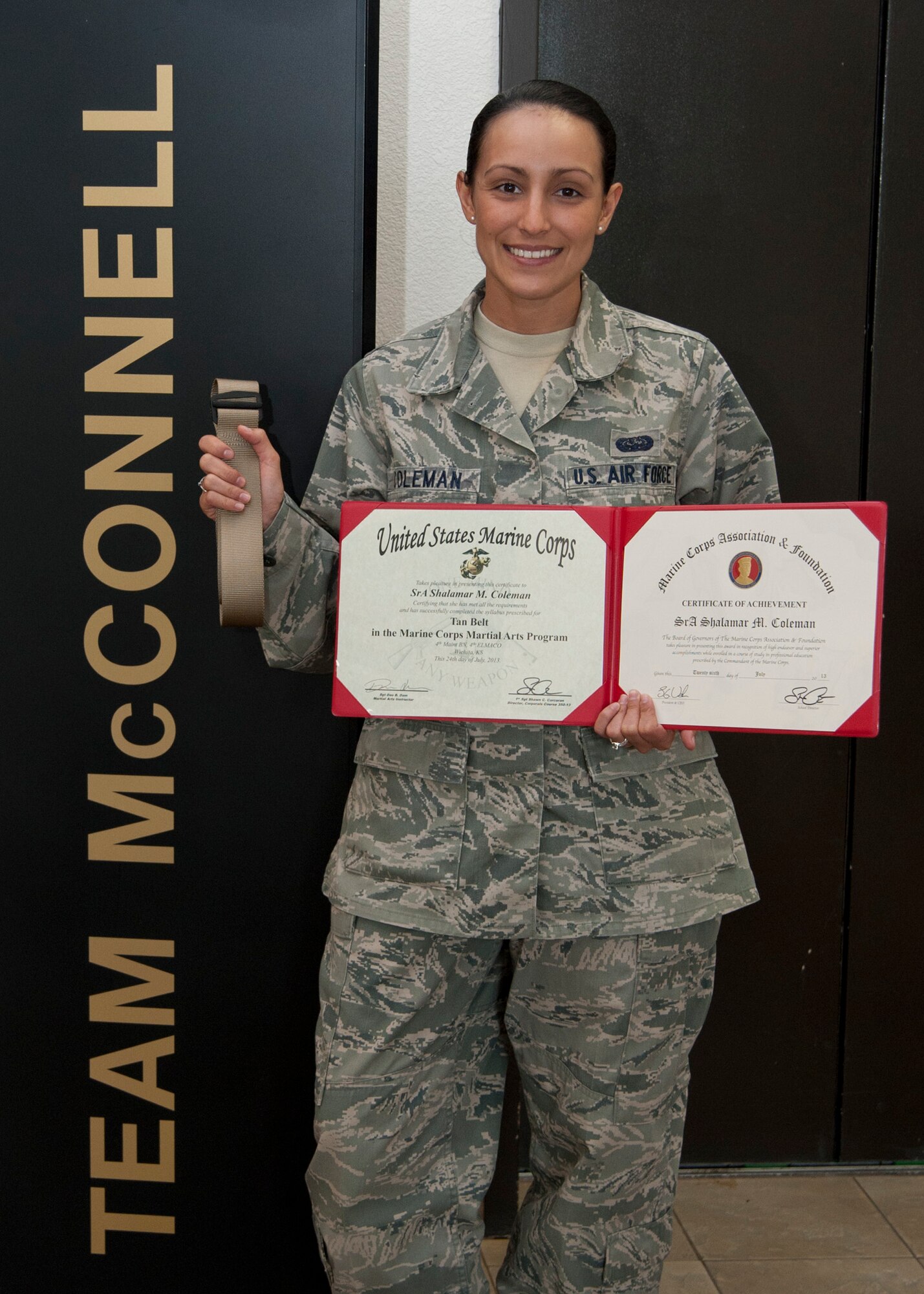 Senior Airman Shalamar Coleman, 22nd Air Refueling Wing knowledge operations manager, poses with her graduation certificate and tan belt she earned during after completing the U.S. Marine Corps Corporals Course July 30, 2013, at McConnell Air Force Base, Kan. Coleman volunteered for the course to increase her leadership skills before going through Airman Leadership School. Her tan belt signifies the completion of entry-level Marine Corps Martial Arts Program requirements, which was one of the facets of her training. (U.S. Air Force photo/Airman 1st Class Victor J. Caputo)