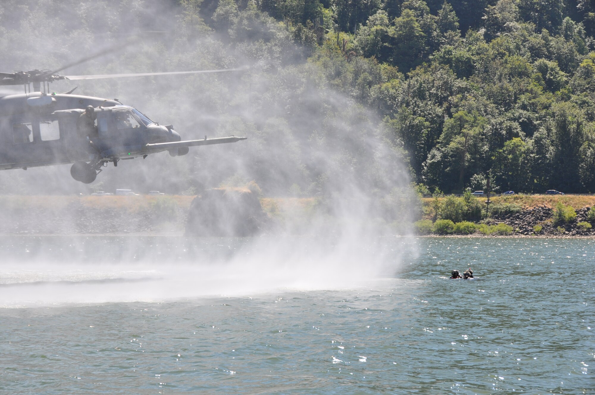 Pararescuemen from the 304th Rescue Squadron, Portland International Airport, Ore. prepare to board an HH-60G Pave Hawk helicopter from the 943rd Rescue Group, Davis-Monthan Air Force Base, Ariz. The 304th RQS and 943rd RQG practiced water rescue operations in the Columbia River, near Rooster Rock State Park, Ore., July 27, 2013. (U.S. Air Force Photo/Staff Sgt. N. Daniel Delgado)