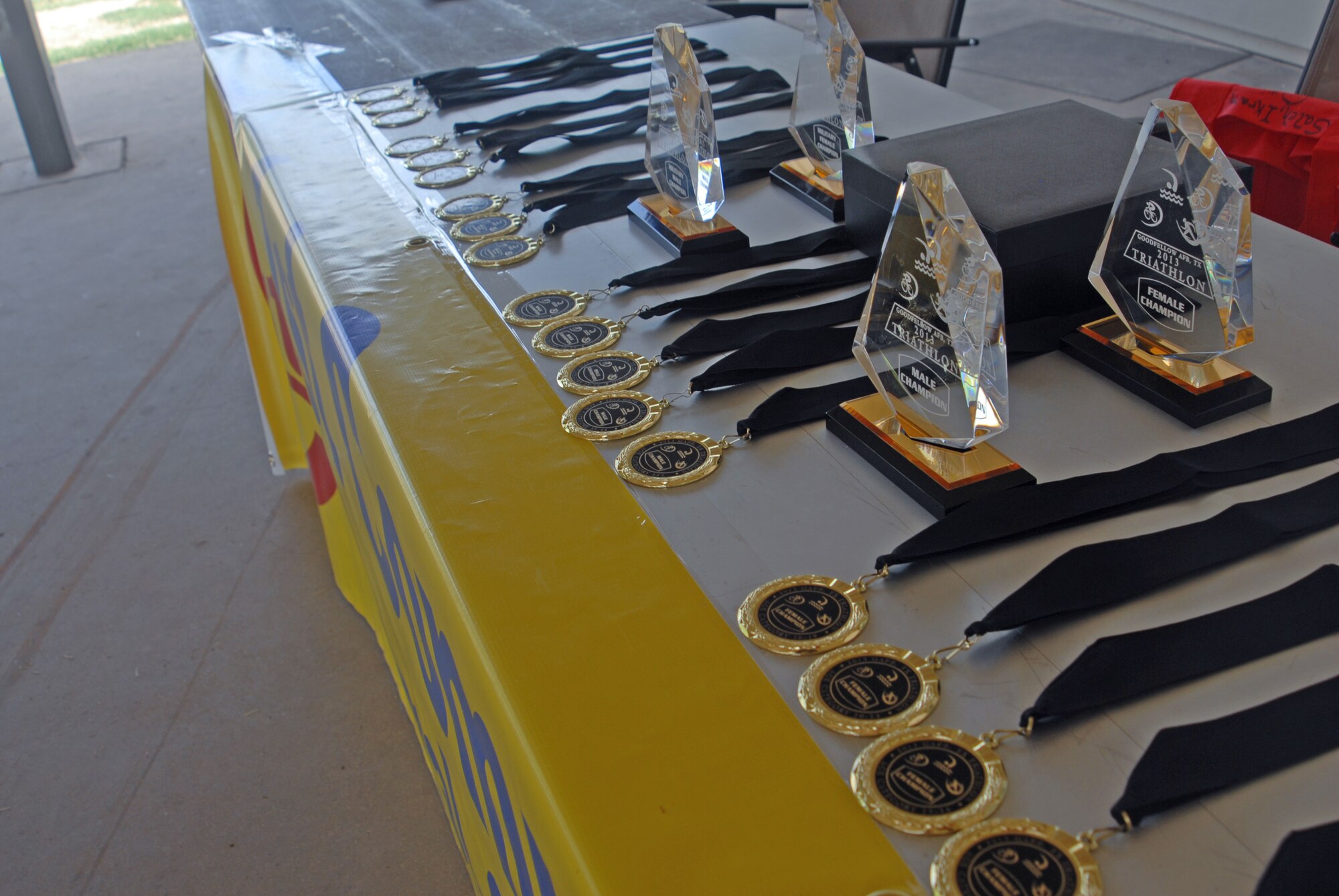 SAN ANGELO, Texas – The awards and medals for the 2013 Annual Triathlon are displayed on a table at the Goodfellow Recreation Camp July 27. The awards and medals were presented to top overall male and female; top male team, female team, and coed team; top military male and female; and squadron participation. (U.S. Air force photo/ Airman 1st Class Breonna Veal)