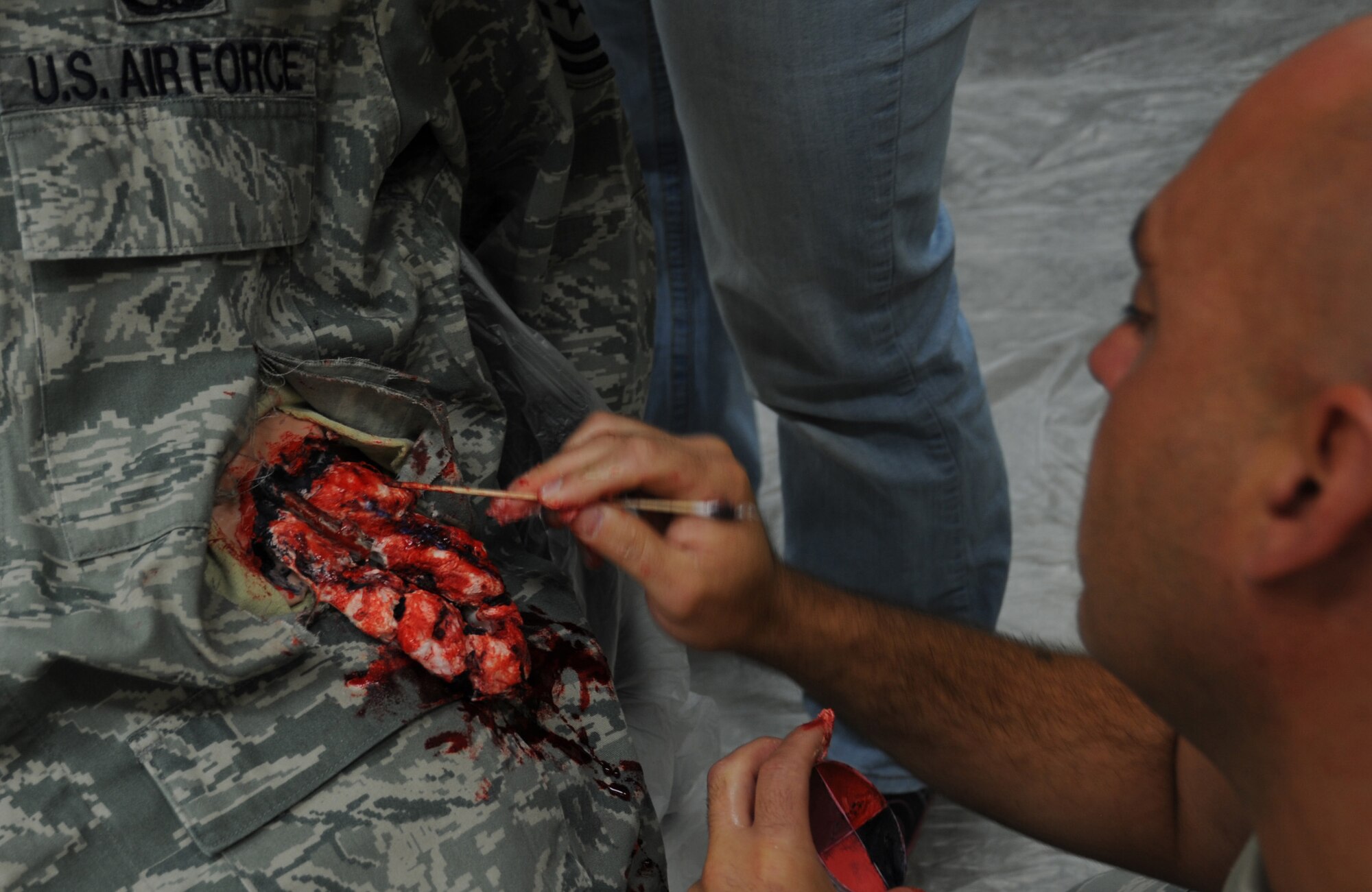 U.S. Air Force Master Sgt. Perry Foster, 366th Fighter Wing executive plans and programs medical liaison, paints cotton balls to simulate an open wound for a Major Accident Response Exercise July 25, 2013, at Mountain Home Air Force Base, Idaho. Multiple base personnel and agencies participated in the MARE during the day. (U.S. Air Force photo by Senior Airman Benjamin Sutton/Released)