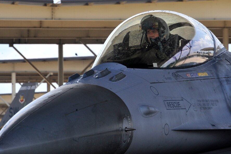 Outgoing 20th Operations Group Commander, U.S Air Force Col. Shaun McGrath, returns a salute as he taxies into the bay for the last time Shaw Air Force Base, S.C., July 25, 2013. McGrath will take command of an Expeditionary Operations Group at an undisclosed location. (U.S. Air Force photo by Airman 1st Class Jonathan Bass/Released)