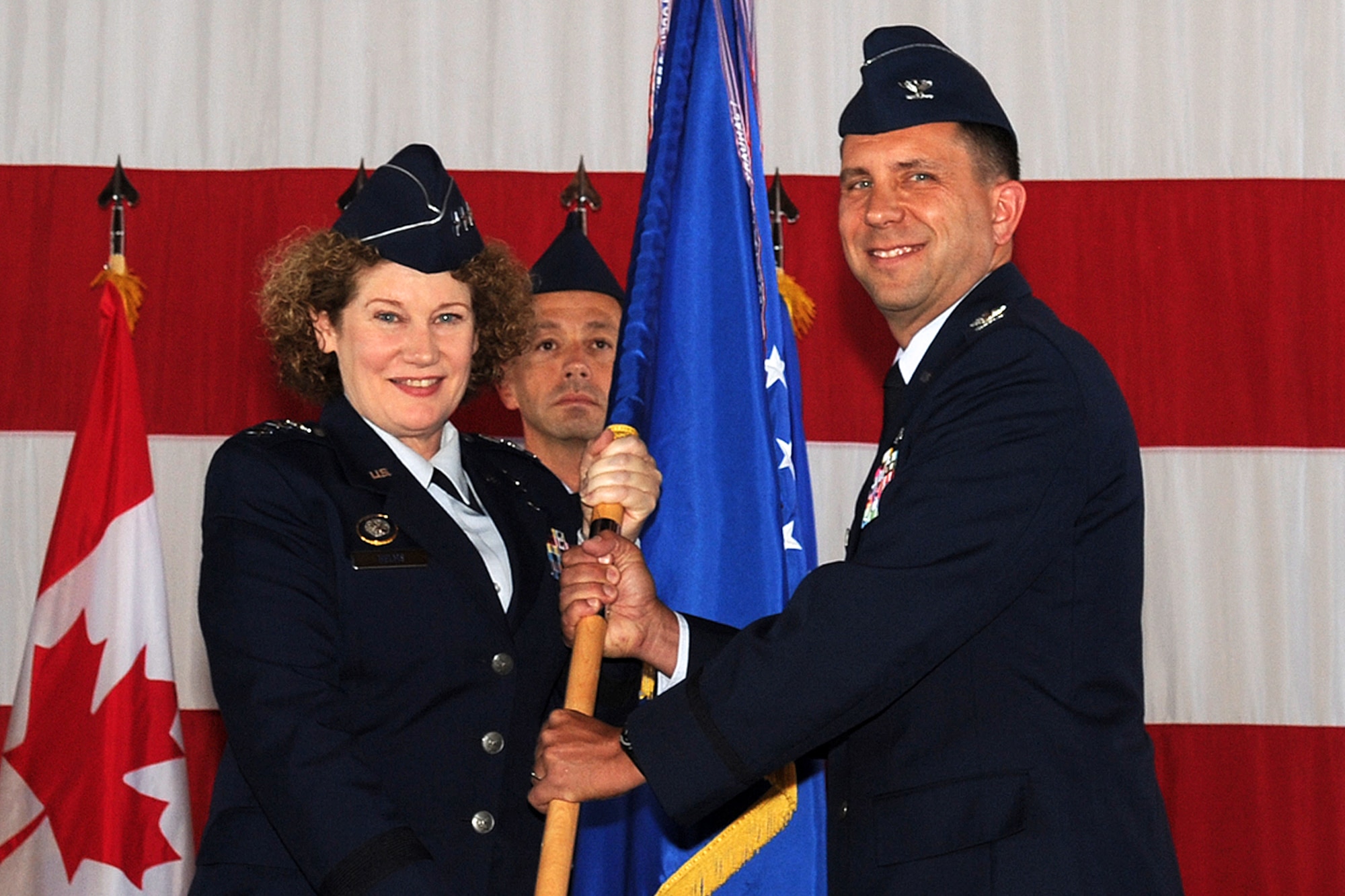 PETERSON AIR FORCE BASE, Colo. – Lt. Gen. Susan Helms, commander of U.S. Strategic Command's Joint Functional Component Command for Space and 14th Air Force (Air Forces Strategic), presents the 21st Space Wing guidon to Col. John Shaw, the new 21st Space Wing commander, during a ceremony here July 26. Shaw replaces outgoing commander Col. Chris Crawford. (U.S. Air Force photo/Rob Bussard)