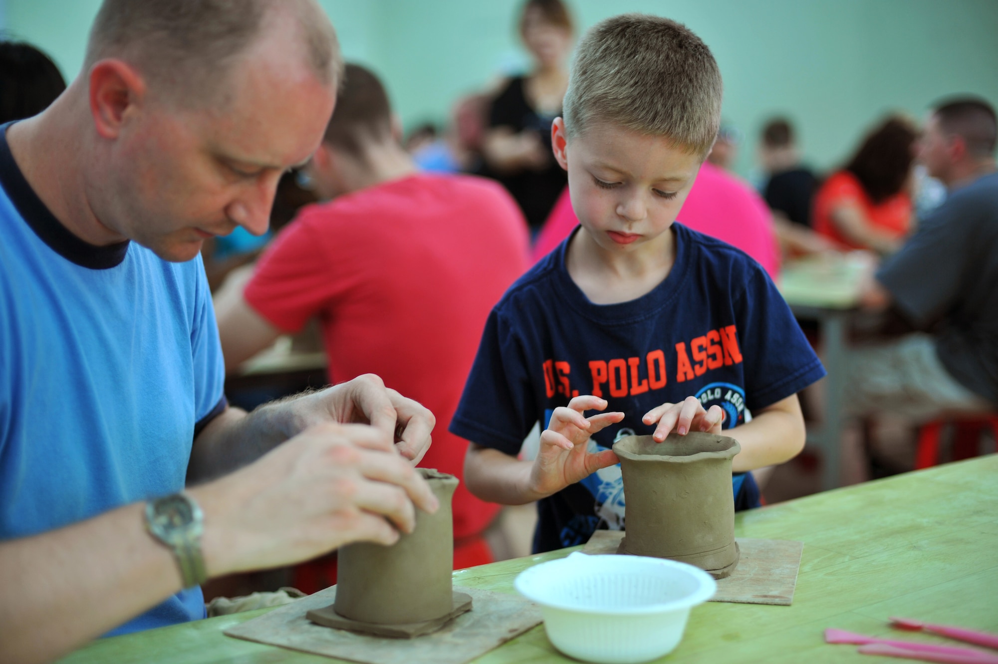 Capt. Brian Kinney, 7th Air Force A1 deputy director, and his son, Aiden, work on their ceramic  projects during the Yeoju culture tour at the Yeoju Ceramic Center in the Gyeonggi Province, Republic of Korea,  July 26, 2013. This free tour is offered only once or twice every year. (U.S. Air Force photo/Staff Sgt. Emerson Nuñez)