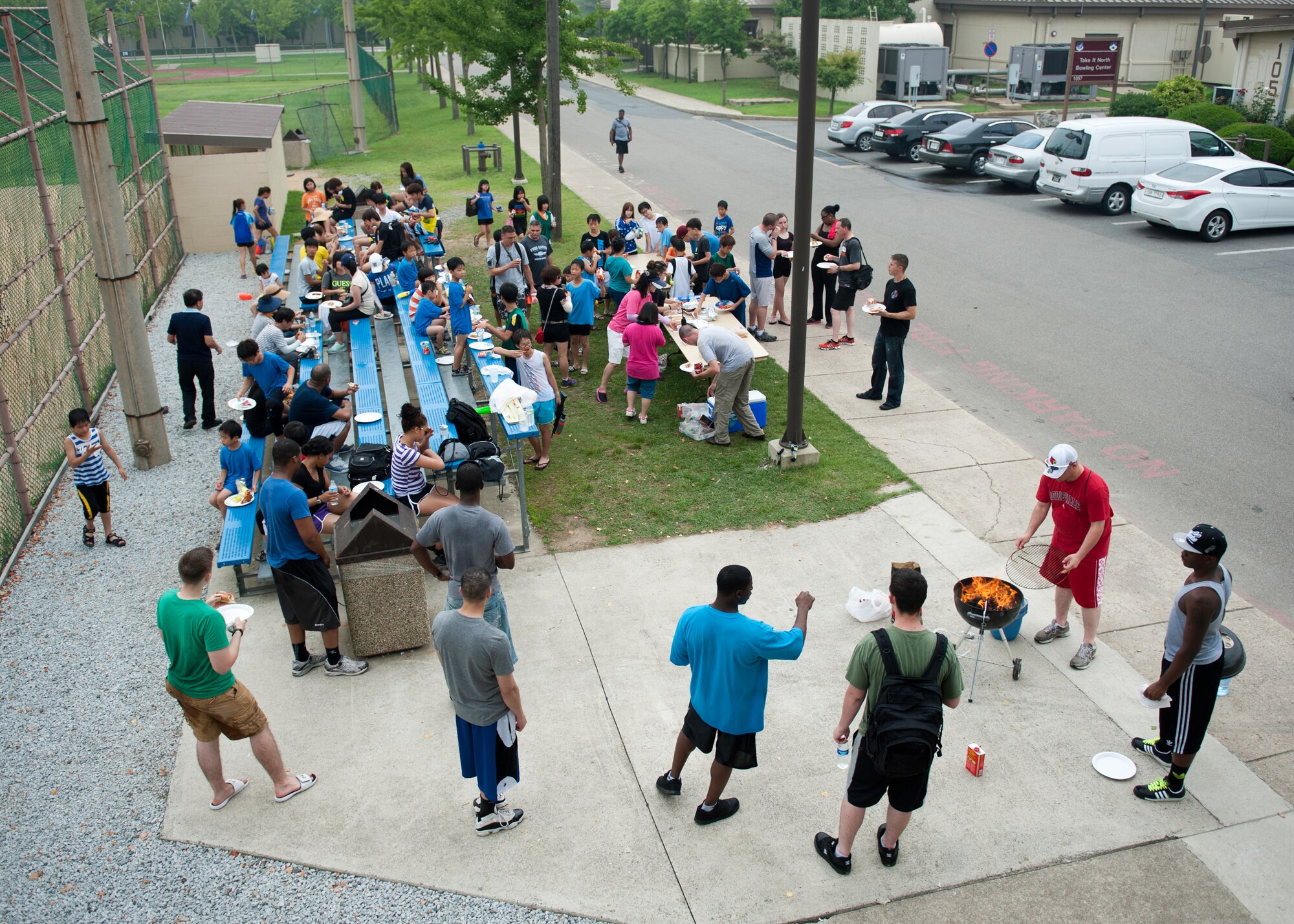 Wolf Pack Airmen and children from the Ilmagwon Orphanage take a break for hotdogs and chips during Summer Fun Day, at Kunsan Air Base, Republic of Korea, July 27, 2013. More than 60 children were invited to the base by the Airmen Committed to Excellence Council for a chance to have fun with members of the Wolf Pack. (U.S. Air Force photo by Senior Airman Clayton Lenhardt/Released)