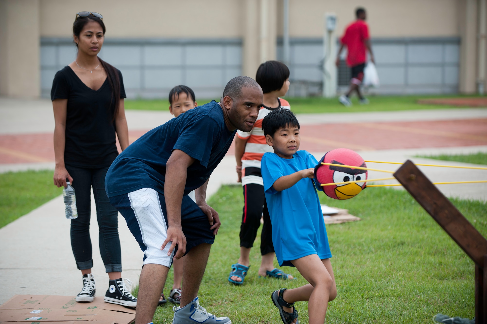 Staff Sgt. Lamar Johnson, 8th Logistics Readiness Squadron, gives advice to a child playing a life-sized Angry Birds game during Summer Fun Day, at Kunsan Air Base, Republic of Korea, July 27, 2013. The child was one of more than 60 who were invited by the Airmen Committed to Excellence Council and gave children from the orphanage a chance to interact with members of the Wolf Pack. (U.S. Air Force photo by Senior Airman Clayton Lenhardt/Released)