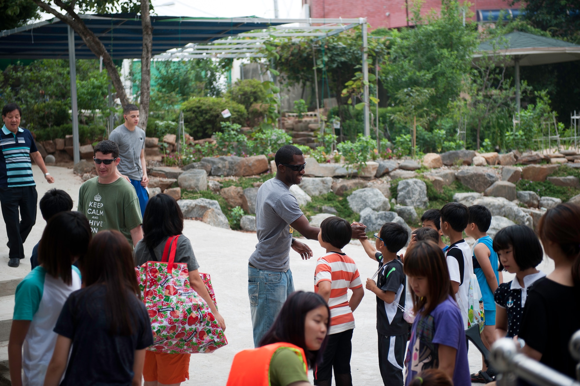 Staff Sgt. Randy Biscette, 8th Logistics Readiness Squadron, greets children at the Ilmagwon Orphanage in Gunsan City, Republic of Korea, July 27, 2013. More than 60 children from the orphanage visited Kunsan Air Base for Summer Fun Day, a day hosted by the Airmen Committed to Excellence Council. (U.S. Air Force photo by Senior Airman Clayton Lenhardt/Released)
