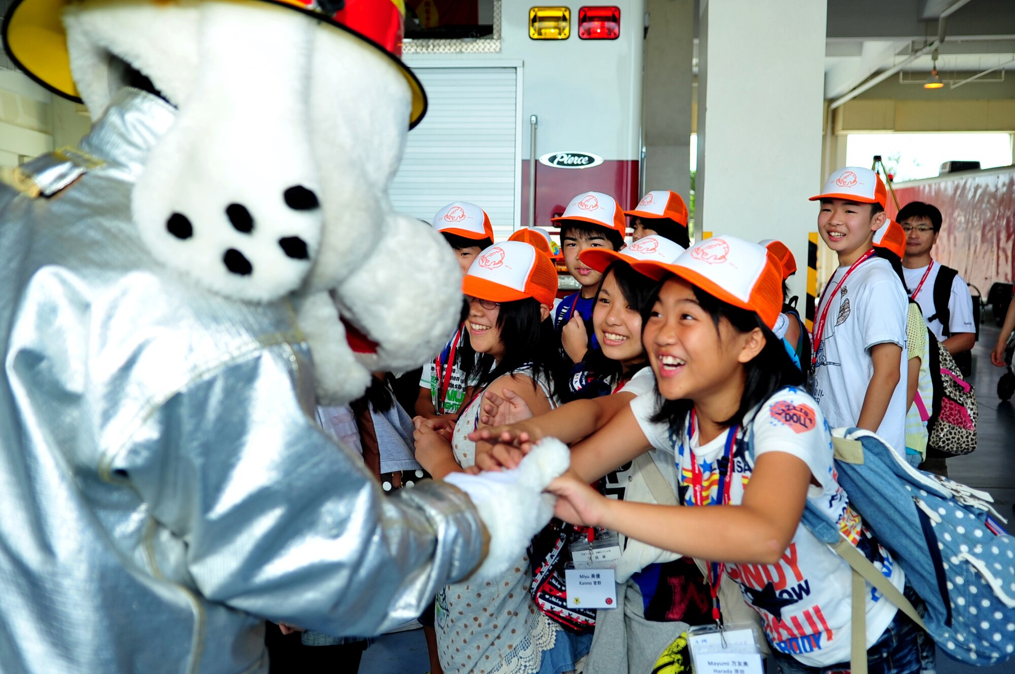 Sparky the fire dog greets Japanese sixth-graders from Iitate Village during a school visit on Kadena Air Base, Japan, July 24, 2013. The students had an opportunity to visit the fire station headquarters, try on fire gear and climb into fire trucks in an effort to learn more about military rescue services. (U.S. Air Force photo by Senior Airman E. N. Jacobs/Released)