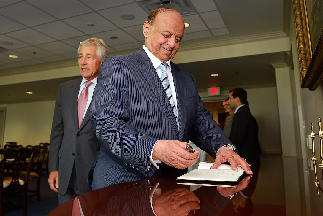 U.S. Defense Secretary Chuck Hagel escorts Yemen's President Abdo Rabby Mansour Hadi, who signs the guestbook during his visit to the Pentagon, July 30, 2013. 