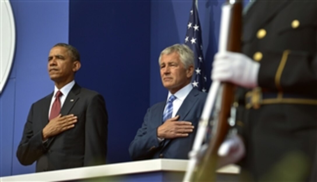 President Barack Obama and Secretary of Defense Chuck Hagel place their hands over their hearts as the National Anthem is played at the start of the ceremony to mark the 60th anniversary of the suspension of the 1950-1953 Korean War at the Korean War Memorial in Washington, D.C., on July 27, 2013.  