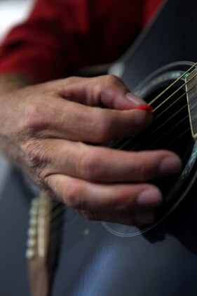 Lt. Col. Jerard A. Brewer, Marine Corps Installations-East Marine For Life officer in charge, strums his guitar aboard Marine Corps Base Camp Lejeune, July 26. Backed by major record companies Rhino Records, Warner Music Group and EMI Music Publishing, GI Jams is a multi-media website created as a platform for military musicians to post and sell original songs as well as upload videos and photos.