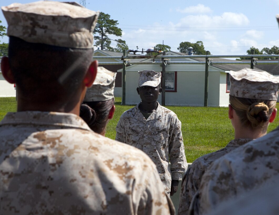 Pfc. Andrews Nsenkyire, squad leader for his personnel administration class, leads students in formation aboard Camp Johnson, July 26. Nsenkyire, previously from Ghana, West Africa, won an immigration visa in 2012 and joined the Marine Corps for a better life.