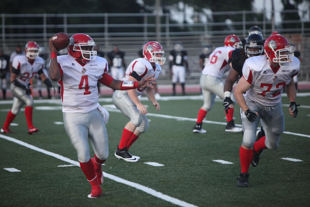 Staff Sgt. Frank Bryant, starting quarterback for the Lejeune Bulldogs, prepares to pass the ball to an open wide receiver during the third of their game versus the Tri-County Crusaders at Liversedge Field aboard Marine Corps Base Camp Lejeune, July 27. The Bulldogs won 34-6 in their second game of the season.