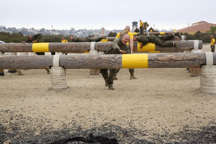 Recruits of Co. G must jump over several logs during the Obstacle Course aboard Marine Corps Recruit Depot San Diego, July 26. The course is designed to improve endurance and confidence in recruits.