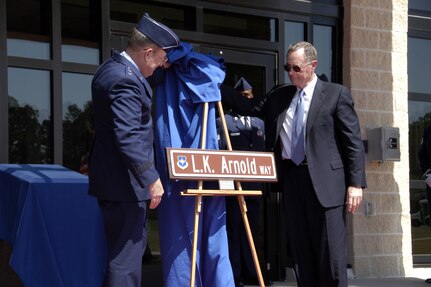 Maj. Gen. Hank Morrow (left) and Maj. Gen. Larry Arnold unveil the new street sign dedicating the access road to the new 1st Air Force headquarters complex in the former 1st AF commander's honor at a ceremony March 13.