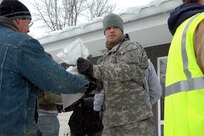 Spc. Christopher M. Rasmussen (in uniform), of Dickinson, works with civilian volunteers near the El Zagel Shrine and Masonic Temple in north Fargo, N.D. Rasmussen and other North Dakota National Guard Soldiers and Airmen have been completely integrated with the civilian populace as they work together to fight the flood.