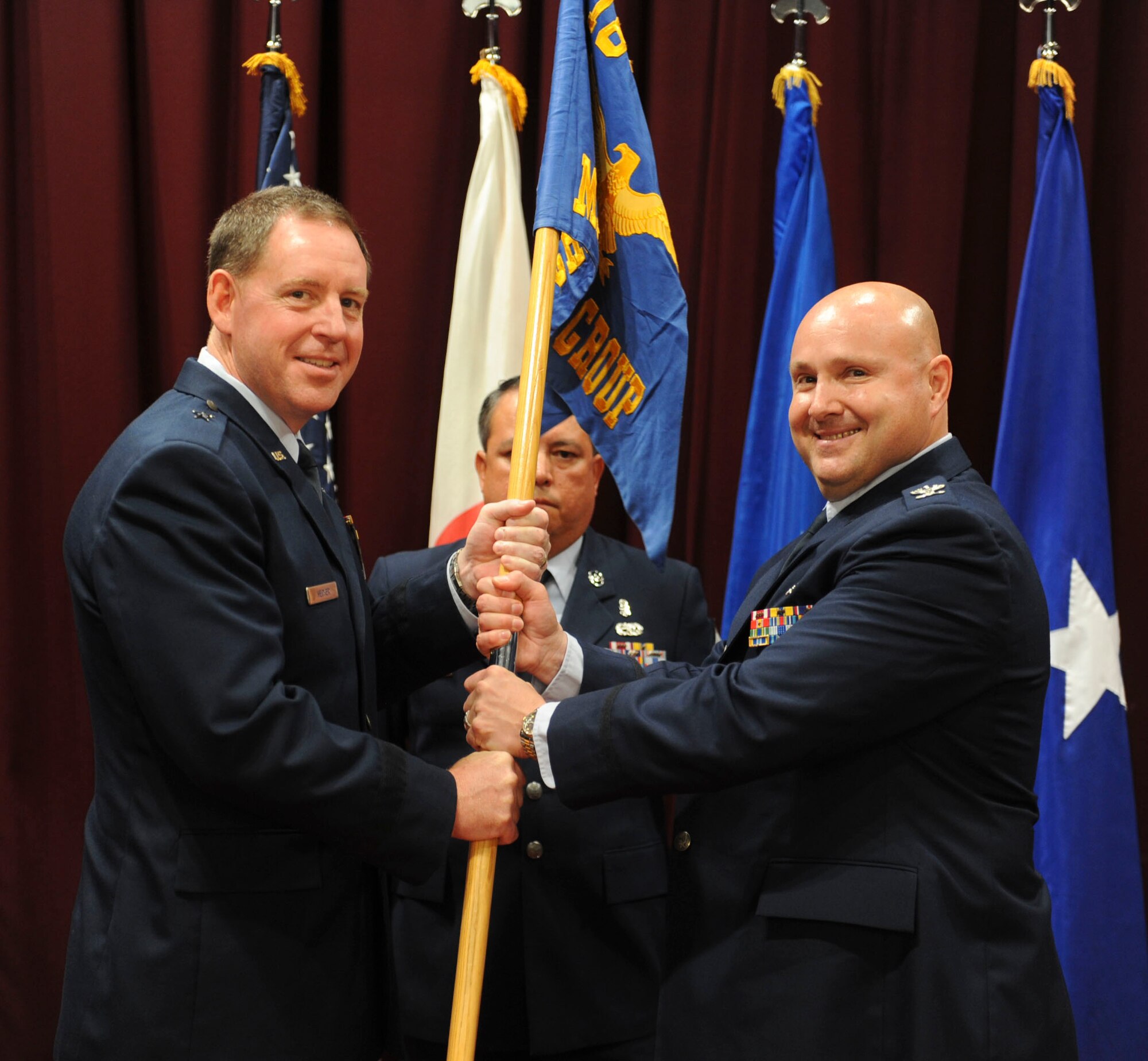 U.S. Air Force Brig. Gen. James Hecker, 18th Wing commander, passes the guidon to Col. Frank Allara Jr., 18th Medical Group commander, during a change of command ceremony on Kadena Air Base, Japan, Aug. 1, 2013. The 18th MDG is the Air Force's largest freestanding ambulatory clinic in terms of assigned personnel, providing extensive medical, dental and support services to Kadena and other Department of Defense beneficiaries living on Okinawa. More than 70 18th MDG medical and dental providers care for nearly 600 patients every day. (U.S. Air Force photo by Airman 1st Class Justin Veazie/Released) 