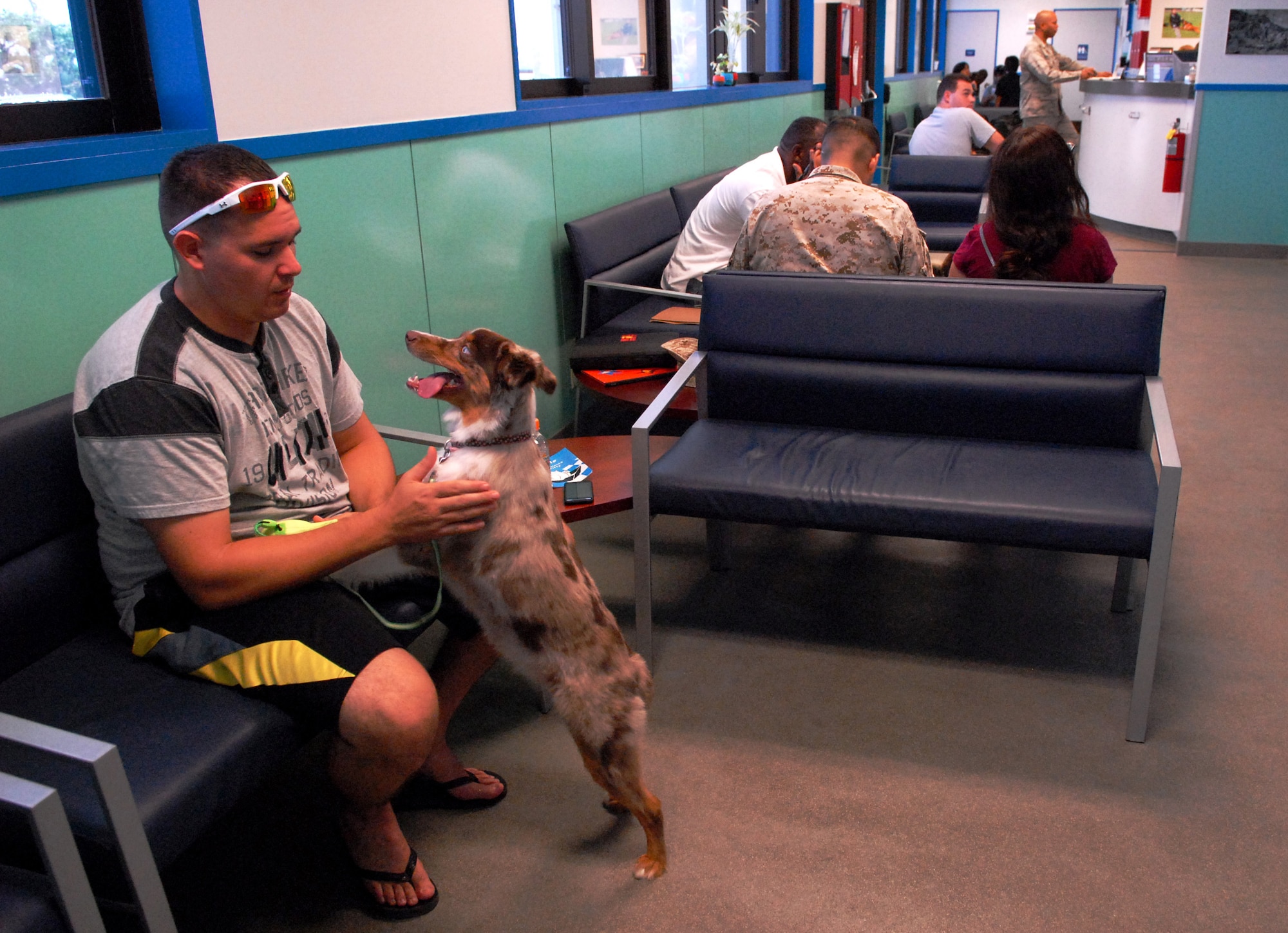 Pet owner Sammy Hicks sits with his dog, Dottie, as they wait in the Okinawa Veterinary Treatment Facility lobby on Kadena Air Base, Japan, July 30, 2013. The vet clinic supports approximately 9,000 animals, including all Status of Forces Agreement individuals' privately owned pets, as well as military working dogs. (U.S. Air Force photo by Staff Sgt. Lauren Snyder/Released)