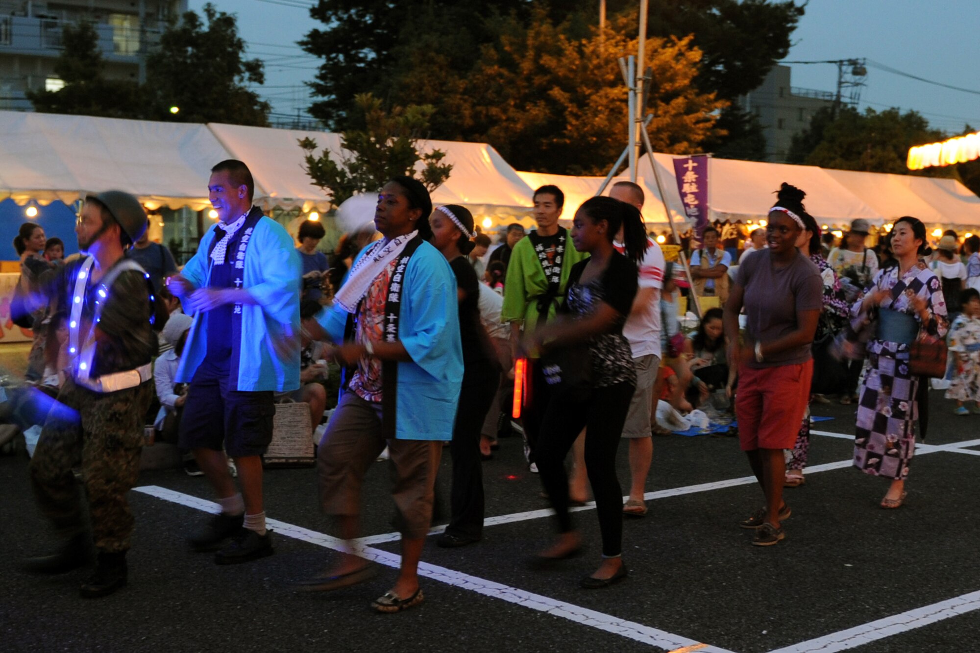 JUJO AIR STATION, Japan -- Airmen and their families from Yokota Air Base, Japan, dance in the Jujo bon-dance festival July 26, 2013, at Jujo Air Station, Japan. The Airmen and their families were invited to experience Japanese culture at the festival. (U.S. Air Force photo by Senior Airman Desiree Economides)