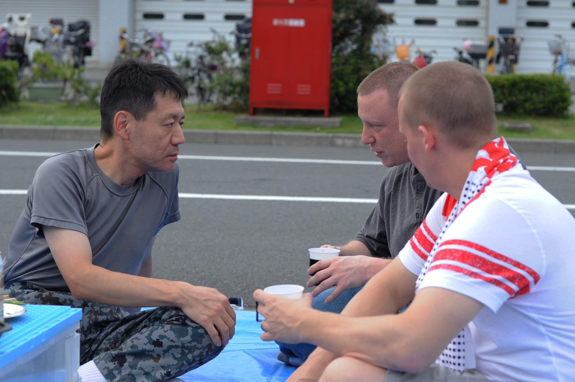 JUJO AIR STATION, Japan -- Lt. Col. Yutaka Yanai, Air Materiel Command planning department operation section chief, talks with Master Sgt. Lee Pedersen and Tech. Sgt. David Boerm, both from the 730th Air Mobility Squadron, July 26, 2013, at Jujo Air Station, Japan. Airmen from Yokota Air Base, Japan, attended a bon-dance festival at Jujo as part of the Japan- U.S. non-commissioned officer exchange program.  (U.S. Air Force photo by Senior Airman Desiree Economides)