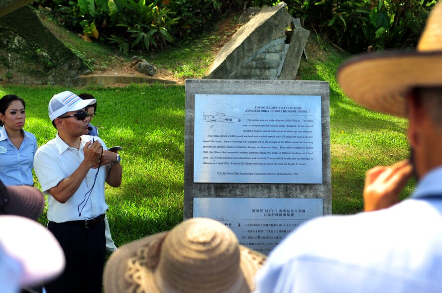 Hideaki Sakihama, 18th Wing Public Affairs community relations specialist, informs Okinawa City citizens of the history of the World War II Japanese aircraft hangars on Kadena Air Base, Japan, July 30, 2013. The hangars housed Yokosuka MXY-7 Navy Suicide Attaker Ohka Model II jets. The Ohka jets were first used during the Battle of Okinawa landings on April 1, 1945. (U.S. Air Force photo by Senior Airman Amber E. N. Jacobs/Released)